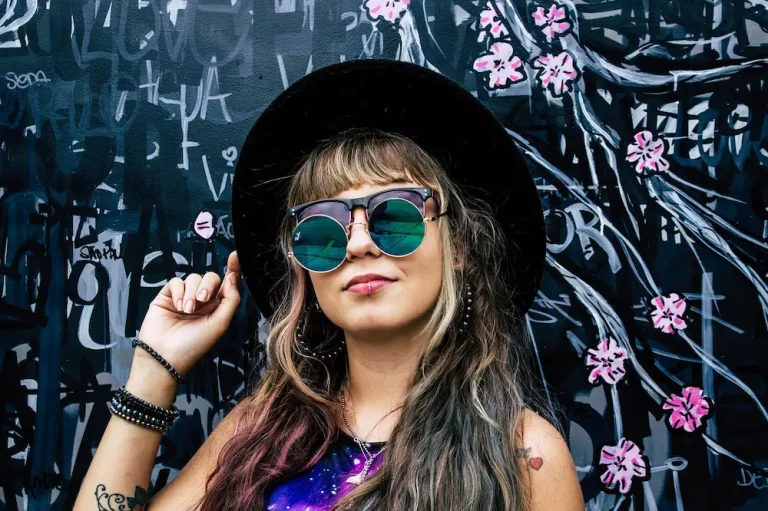 Mujer con gafas de sol reflectantes y sombrero negro